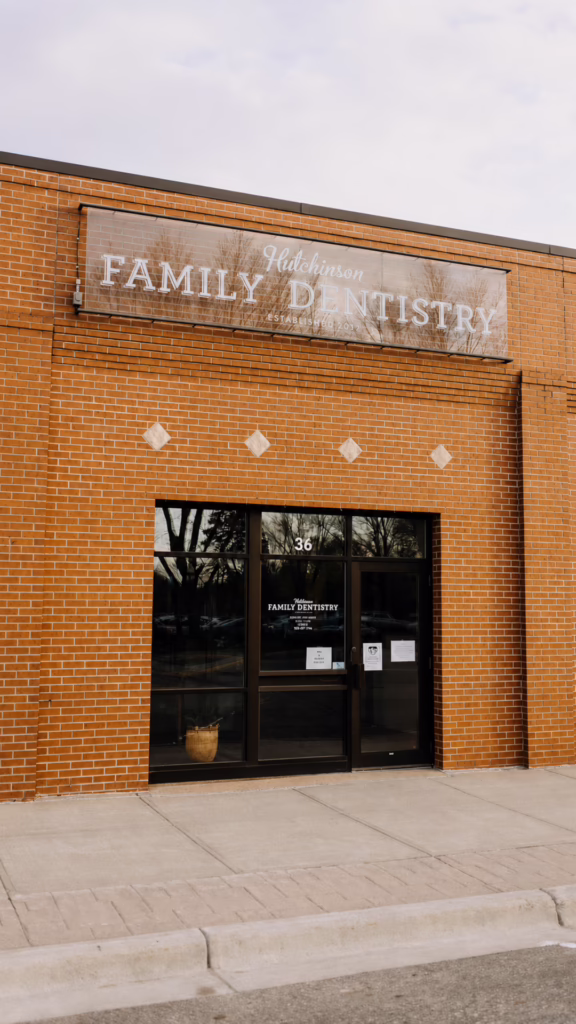 Storefront of Hutchinson Family Dentistry on a red brick building with a large sign above the entrance
